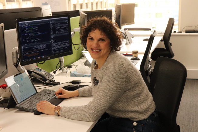 Elisa Capecci sitting at her computer desk.