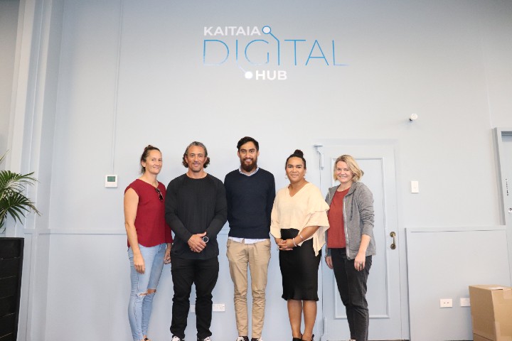 Chev and Jason stand with Kaitaia Digital Hub members and a DIA member in the office.