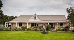 Front of Reyburn House, Whangarei, with garden in flower and modern sculpture on front lawn.