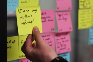 Hand holding a Post-it note with user quote 'I am my mother's internet'.